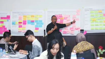 A man standing pointing to the presentation