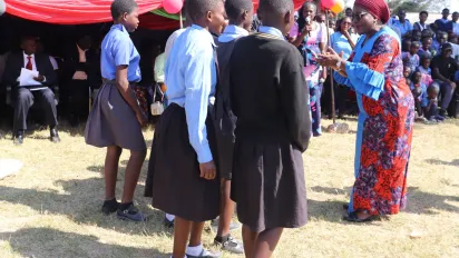 Labour Minister, Ms. Brenda Tambatamba joins in the dance with pupils at the commemoration.