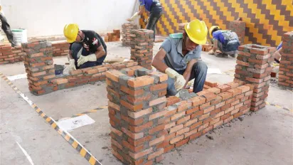 Wokers demonstarting bricklaying.