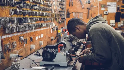 Man in Grey Hoodie Jacket Holding Black Metal Near White Socket Power Supply