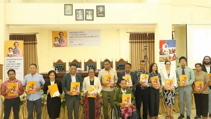People standing and holding a book