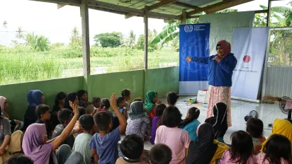 teacher standing with child labourers learning