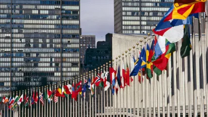 Row of countries flags next to UN Headquarters in New York
