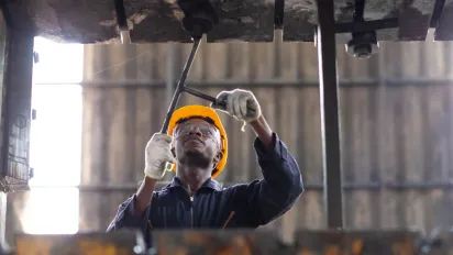 Young black male engineer checking and repairing the machine in Heavy Industry Manufacturing Facility
