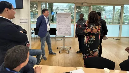 Group of people standing around a flipchart
