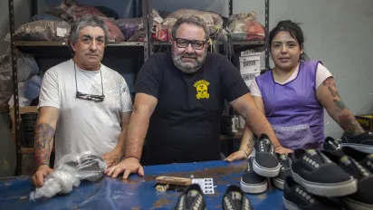 Argentina: tres trabajadores, dos hombres y una mujer, de una cooperativa de fabricación de calzado