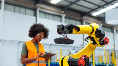 Young african woman controlling industrial machine with digital tablet 