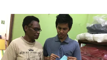 a male university student assists a female entrepreneur in Papua, Indonesia 