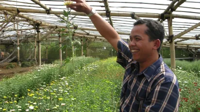 a male farmer smiling in his flower field