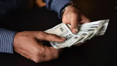 Photo of hands counting money, dark background