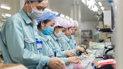 Workers check electronic components at a factory in Viet Nam. 