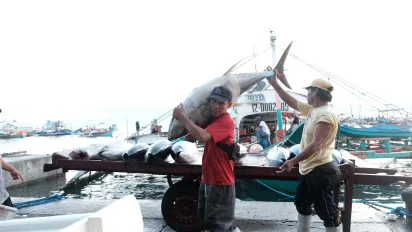 A man carrying a big fish.