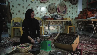 A woman pressing dates in Basra, Iraq