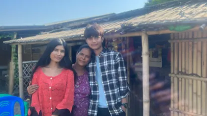 Bhutanese refugee siblings with their mum in front of their shop