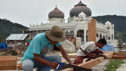 two male carpenters rebuilding the surroundings of a mosque in Aceh