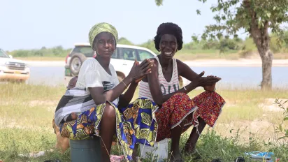 2 femmes assises dans l'herbe proche d'une rivière
