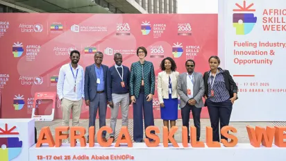 Seven members of the ILO team stand smiling in front of a red Africa Skills Week 2025 backdrop in Addis Ababa, Ethiopia.