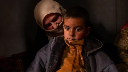 Syrian agricultural worker Aisha Al Mohammed and her youngest son sit inside a tent in their informal settlement in Lebanon’s Bekaa Valley. December, 15, 2025 