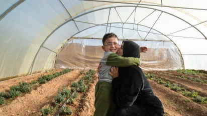 Syrian efugee mother hugging her son in Mafraq, Jordan