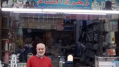 man in Egypt in front of small homeware shop 
