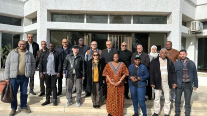 Photo de groupe de la délégation et de l’équipe IPDLI devant un bâtiment.