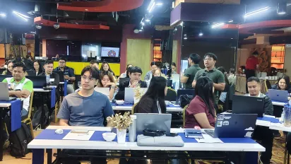 Trade officials participate in a training using their computers and AI