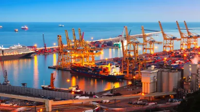 Industrial port of Barcelona, displaying container cranes, containers, ships - evening shot