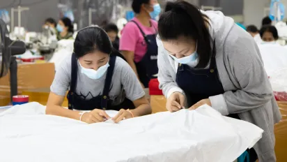 Two female workers sewing garments. 