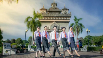 Group of student pose in front of a city gate.
