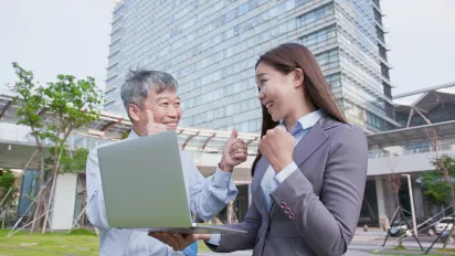 Older and young worker celebrating work
