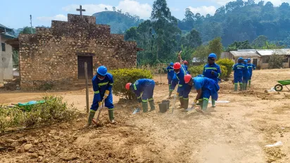 Female trainees in protective gear shape the roadside carriageway by hand at the Tubah training worksite.