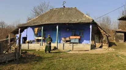 Woman in front of her house in Moldova.