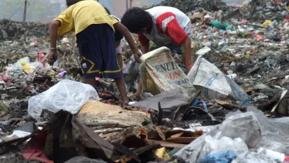 Two boys while pick through garbage for recyclable materials.