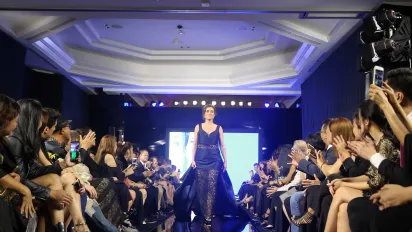 a fashion model on a ramp with people watching