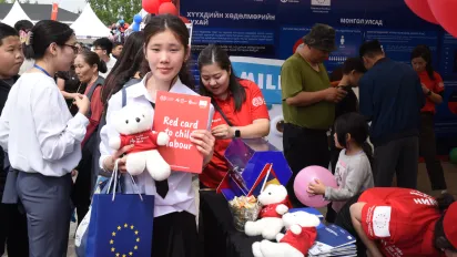 A participant holds a “Red Card to Child Labour” message during a public awareness campaign organized at Europe Day 2026 in Darkhan-Uul province.