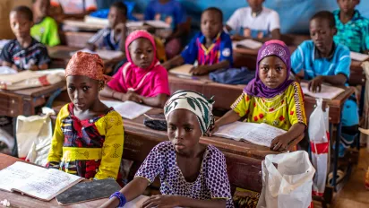 Children sit behind desks in a classroom in Mali.