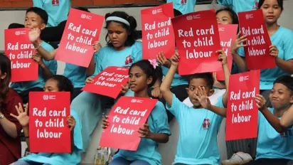 Children holding red card posters