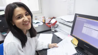 Entrepreneur Merima Kukić Gego does administrative work at a desk with a computer.