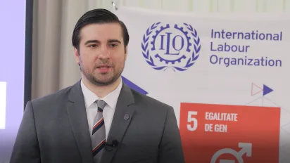 Man speaking in front of ILO banner