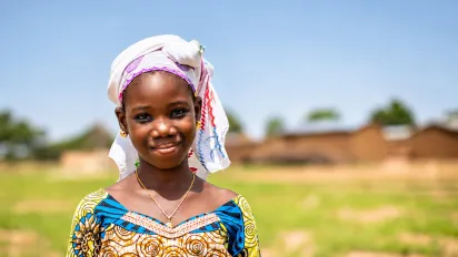 Une fille au Mali regarde l'objectif et sourit