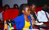 A woman with disability speaking from the audience in the training with jornalists