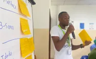 Formando em sala a falar com microfone durante ação de formação