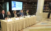 Cinco pessoas sentadas a uma mesa numa apresentação pública