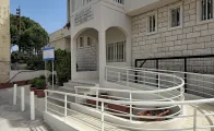 the photo show a white accessibility ramp installed in front of the municipality building in Deddeh