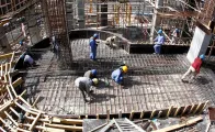 Migrant workers lay down supporting rods for a floor at a construction site in Doha Qatar.
