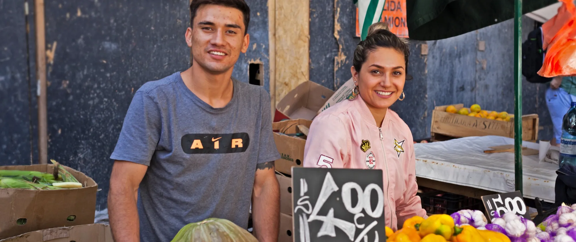 Jóvenes venden verduras en el mercado