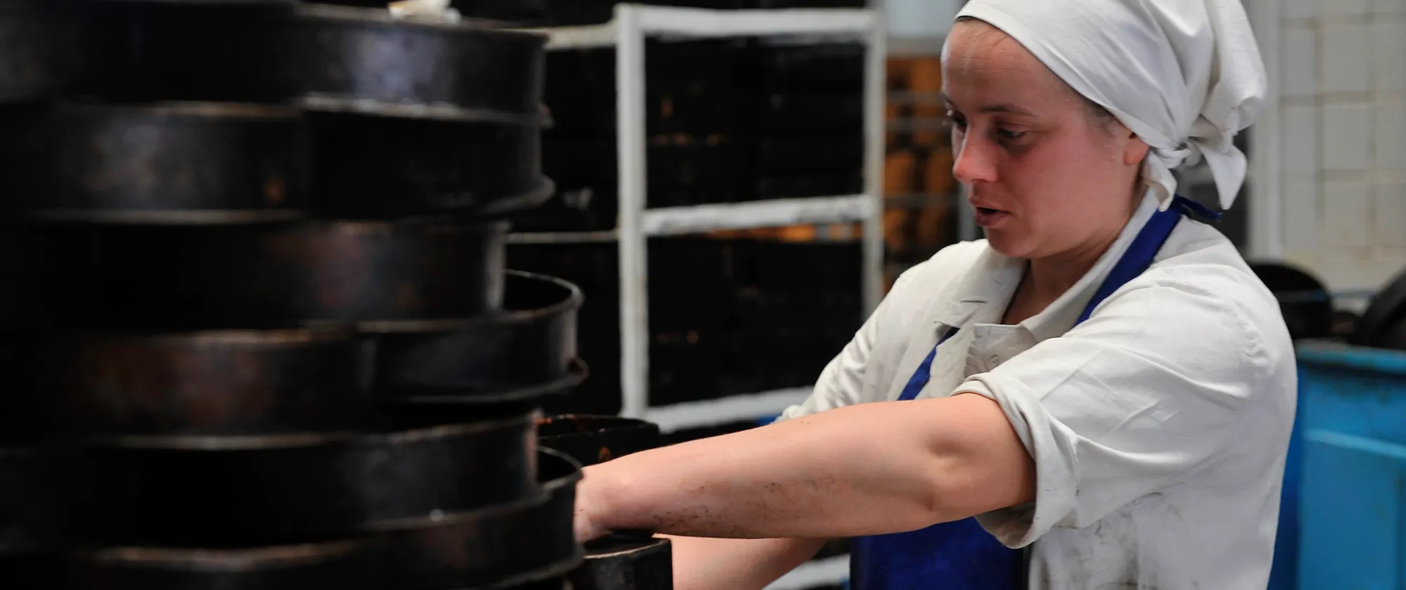 Young woman cleaning cake moulds.