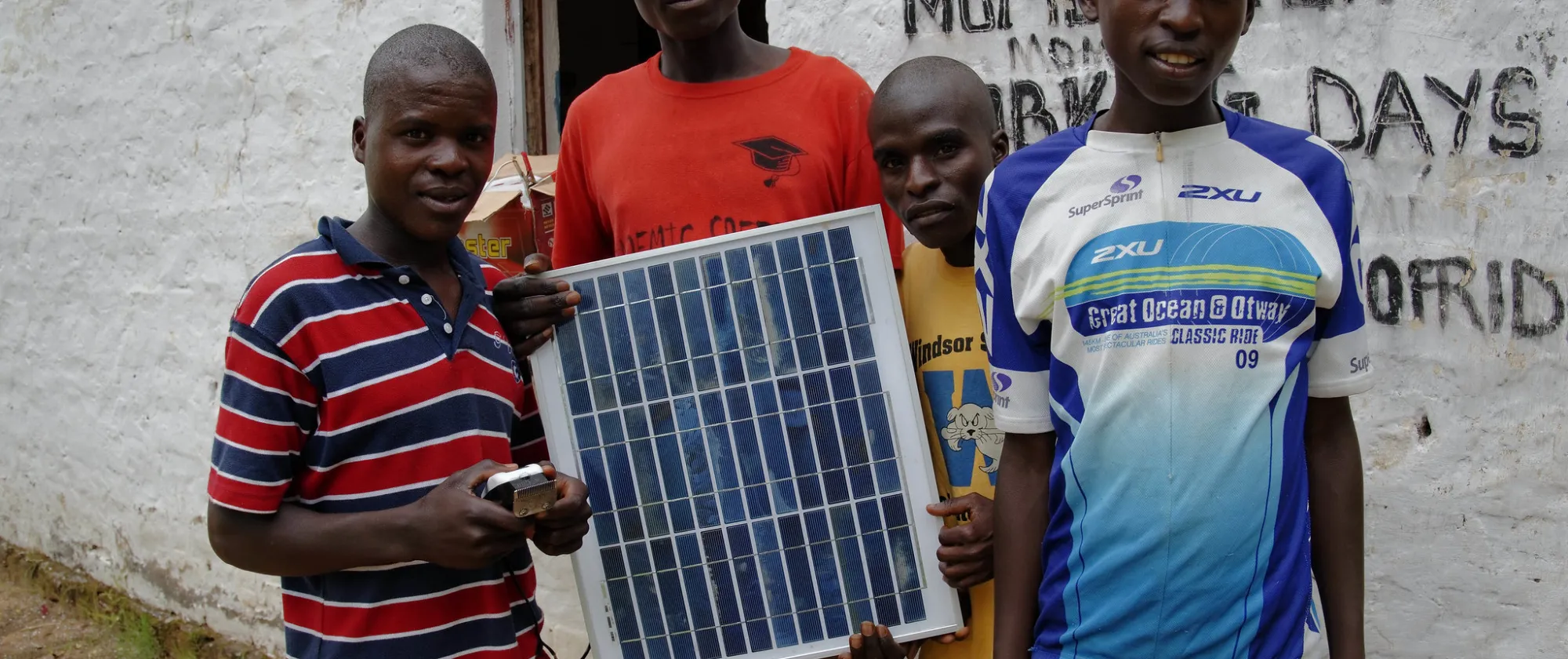 4 men holding a solar panel
