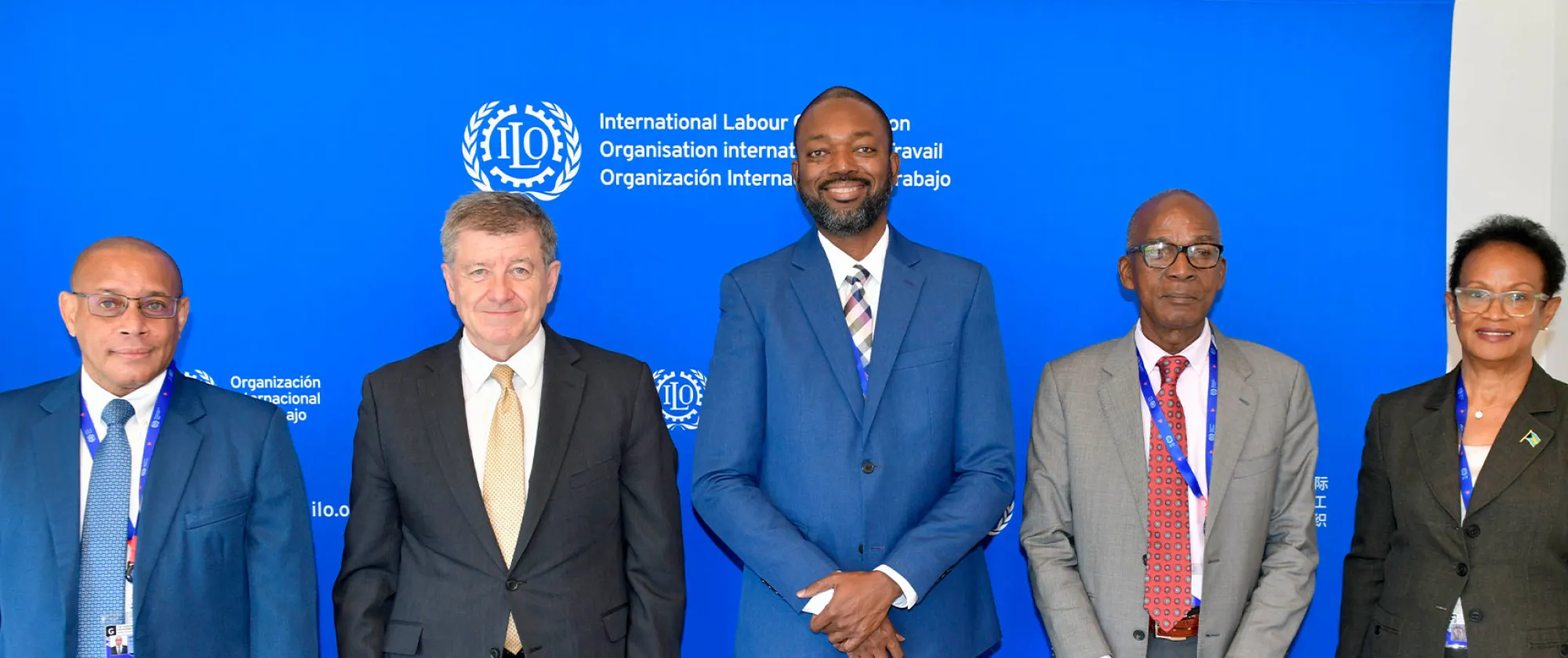 Five people standing in front of a blue backdrop