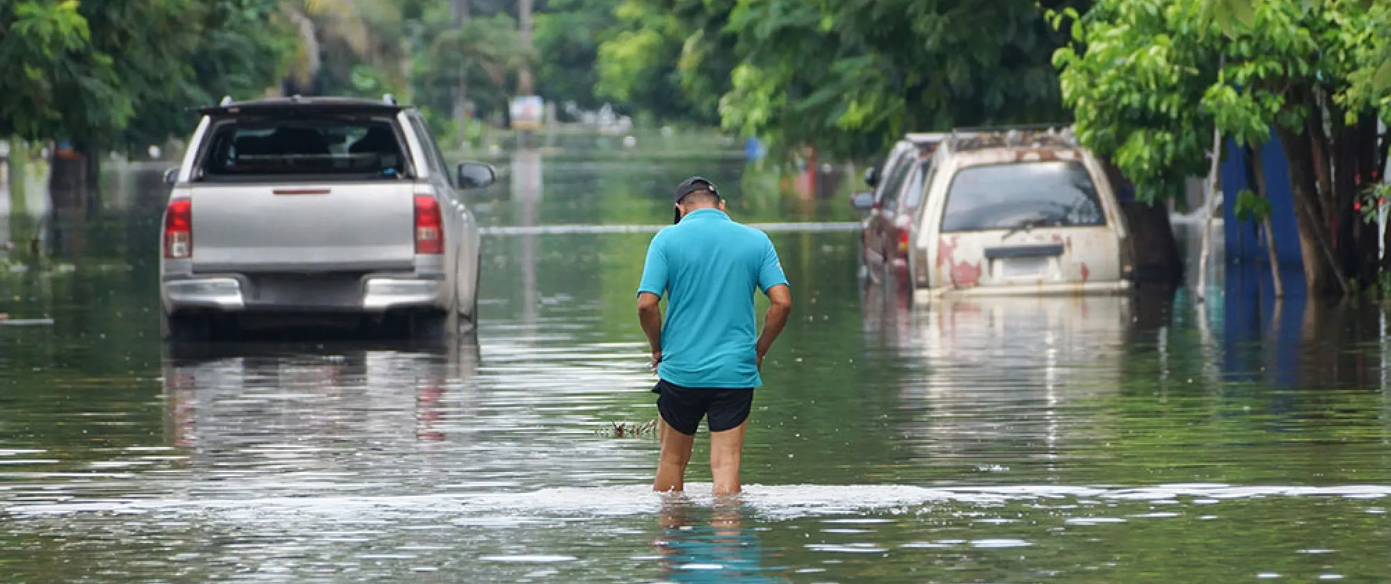 Man walking through flood waters